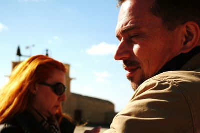 Close-up of young couple with sunglasses against sky