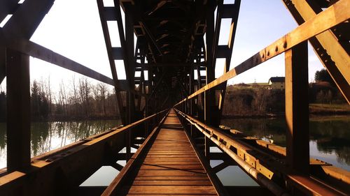 Footbridge over river against sky