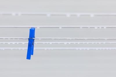 Close-up of clothespins hanging against white background