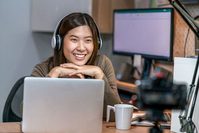 Portrait of a smiling young woman using phone