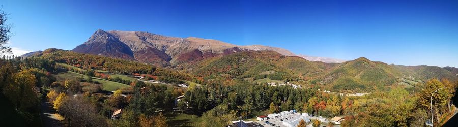 Panoramic view of mountains against clear blue sky