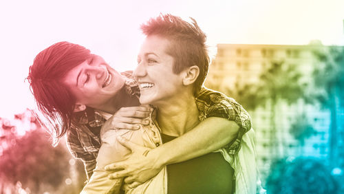 Smiling lesbian couple against buildings