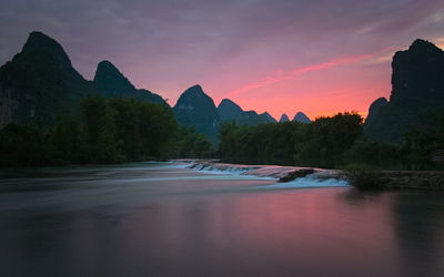 Scenic view of river against sky during sunset