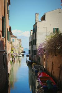 Boats in canal along buildings