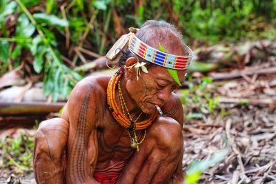 Portrait of young man sitting on field