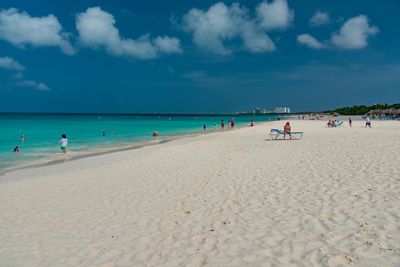 People at beach against sky