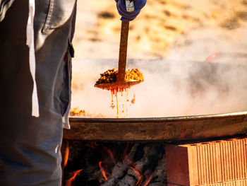 Low angle view of man preparing food on barbecue grill