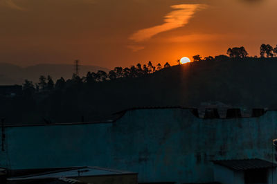 Silhouette buildings against sky during sunset