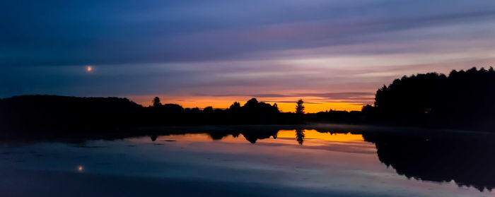 Scenic view of silhouette trees against sky at sunset