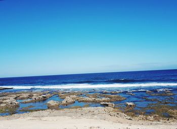 Scenic view of sea against clear blue sky