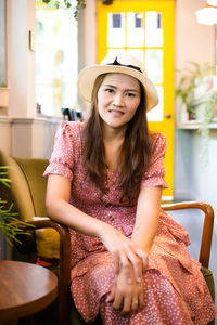 Portrait of a smiling young woman sitting on chair