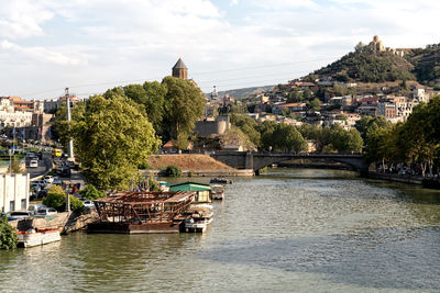 River amidst buildings in city against sky