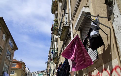 Low angle view of flags hanging amidst buildings in city