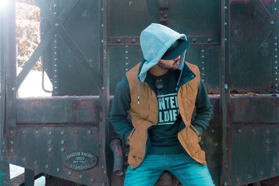 Young man standing against train