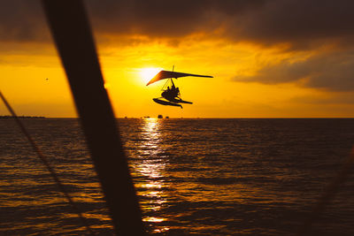 An hang glider flies over the sea at sunset. summer activities. sport. high quality photo