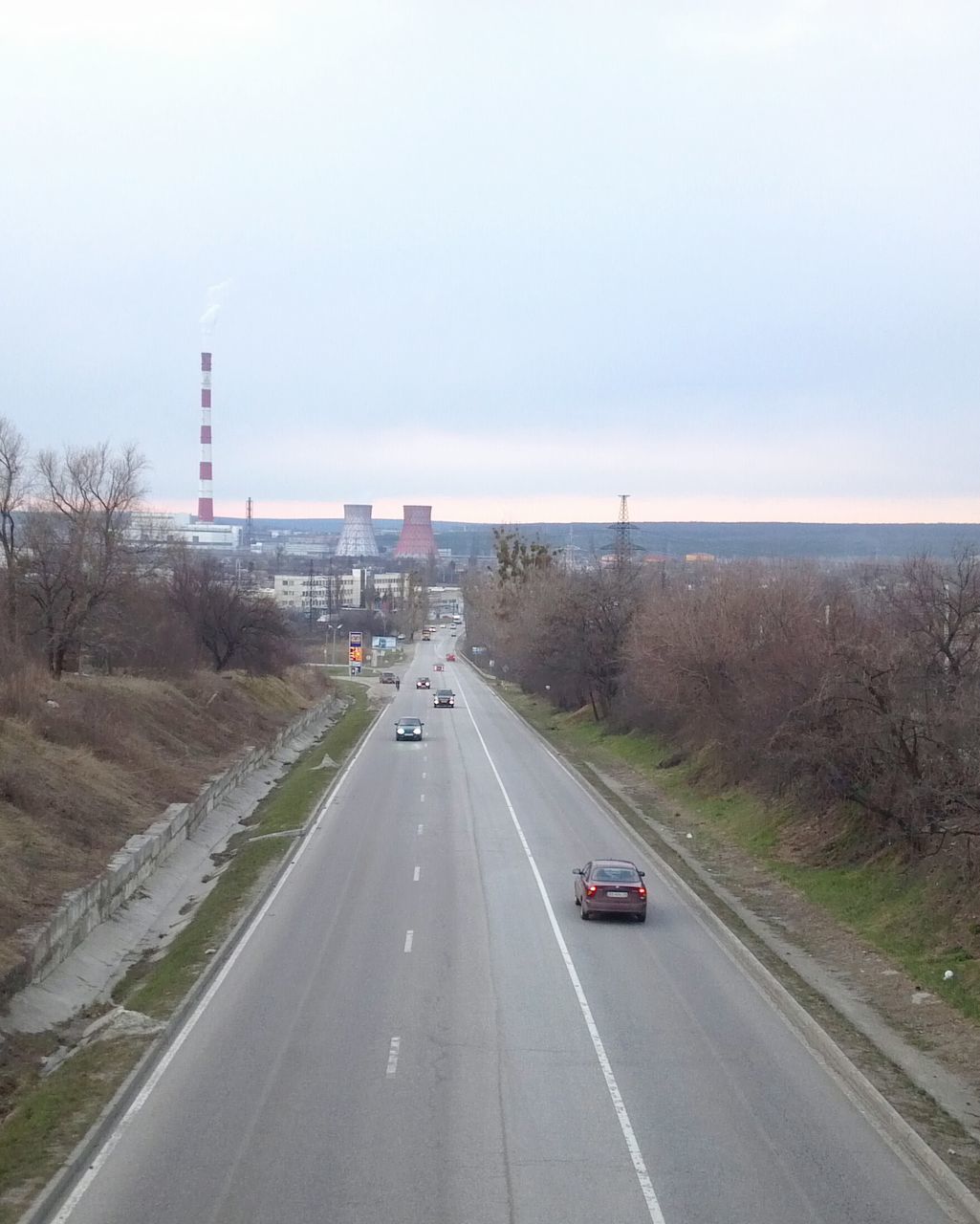 transportation, road, car, land vehicle, road marking, mode of transport, built structure, architecture, the way forward, high angle view, street, sky, building exterior, copy space, on the move, highway, travel, city, vanishing point, connection