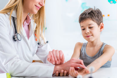 Female doctor examining boy at clinic