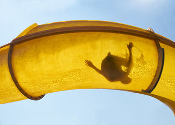 Silhouette of person sliding down water slide