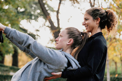 Smiling women exercising in park