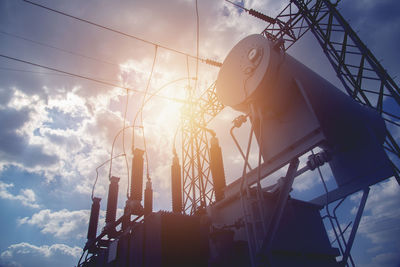 Low angle view of silhouette cranes against sky