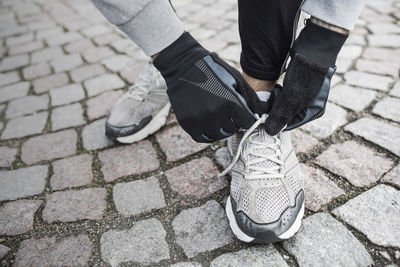 Low section of man tying sports shoe's lace