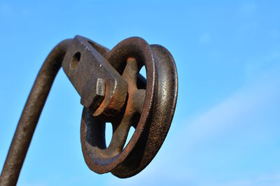 Close-up of rusty metal against clear blue sky