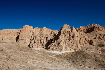 Scenic view of rocky mountains against clear blue sky