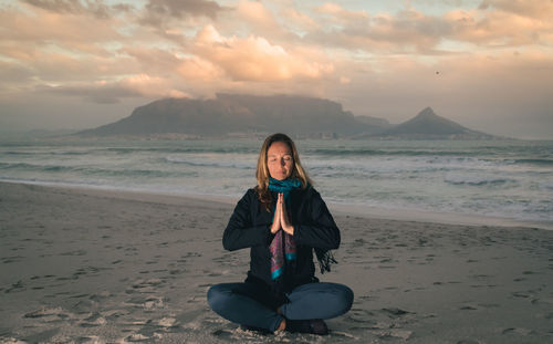 Silhouette of woman meditating on beach