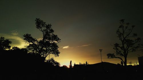 Silhouette trees against sky at night