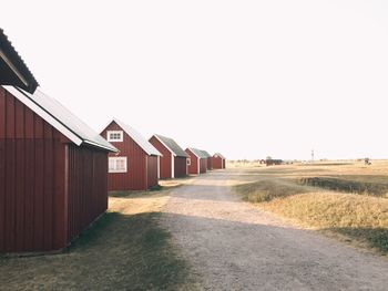 Houses amidst field against clear sky