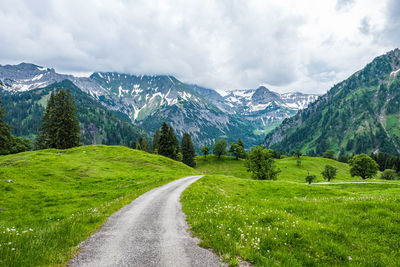 Road amidst green landscape against sky