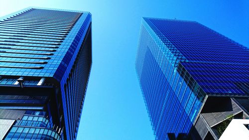 Low angle view of modern buildings against clear blue sky