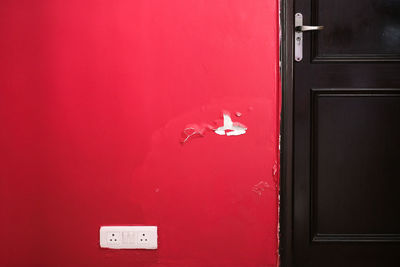 Close-up of closed door and red wall
