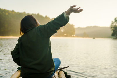 Solo asian woman travel by thai local bamboo boat in tropical forest and lake in autumn season