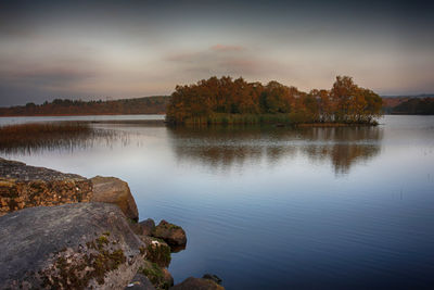 Scenic view of lake against sky at sunset