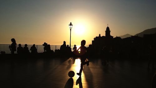 Silhouette of people at town square during sunset