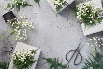 Close-up of flowers with scissors and string on table