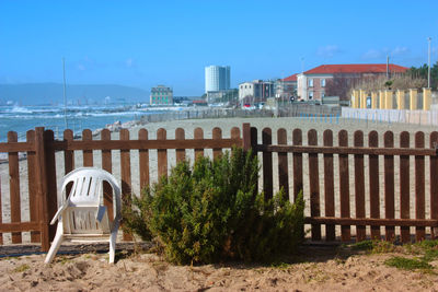 Scenic view of beach by buildings against sky