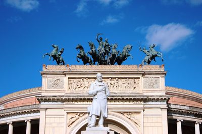 Low angle view of statue against blue sky