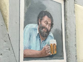 Portrait of man wearing eyeglasses on wall