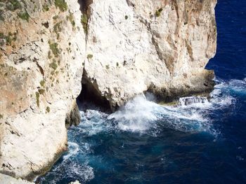 High angle view of waves splashing on rock formations