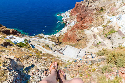 Low section of woman on cliff over sea