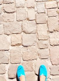 Low section of woman standing on footpath