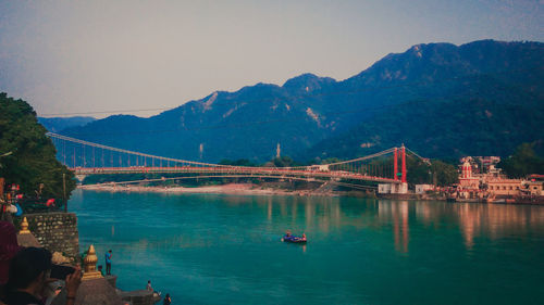 Bridge over lake with mountain range in background