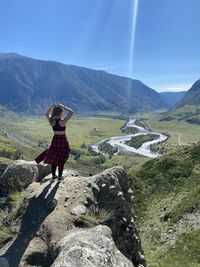 Women standing on rocks against mountain range