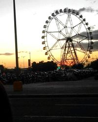 Ferris wheel against sky at sunset