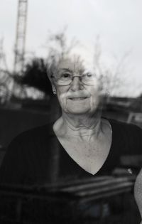 Portrait of senior woman looking through window