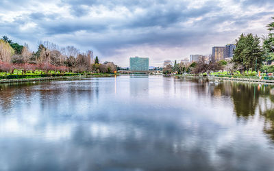 Lake and buildings against sky