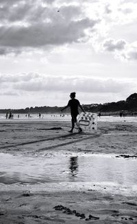 Man standing on beach against sky