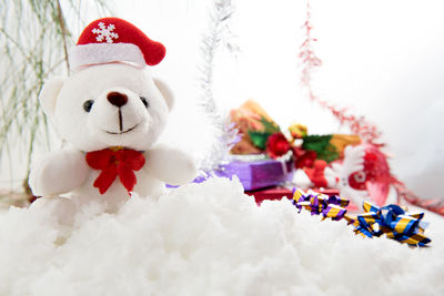 Teddy bear and christmas presents on fake snow